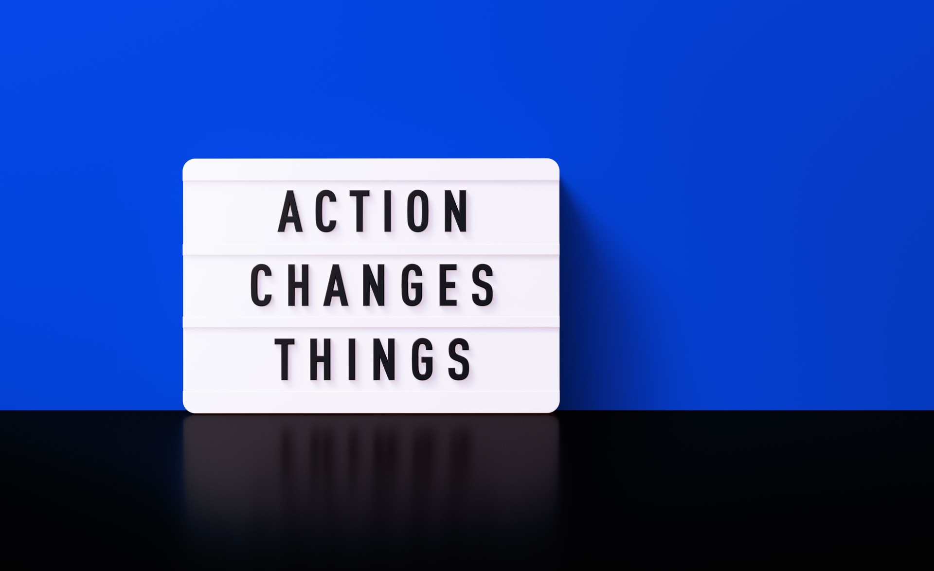 Action Changes Things Written White Lightbox Before Blue Wall